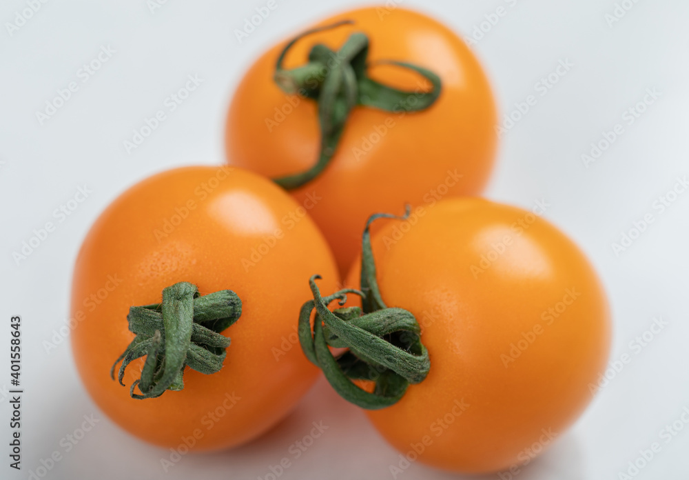 Yellow tomatoes on light white background, flat lay Yellow tomatoes on light white background, flat lay