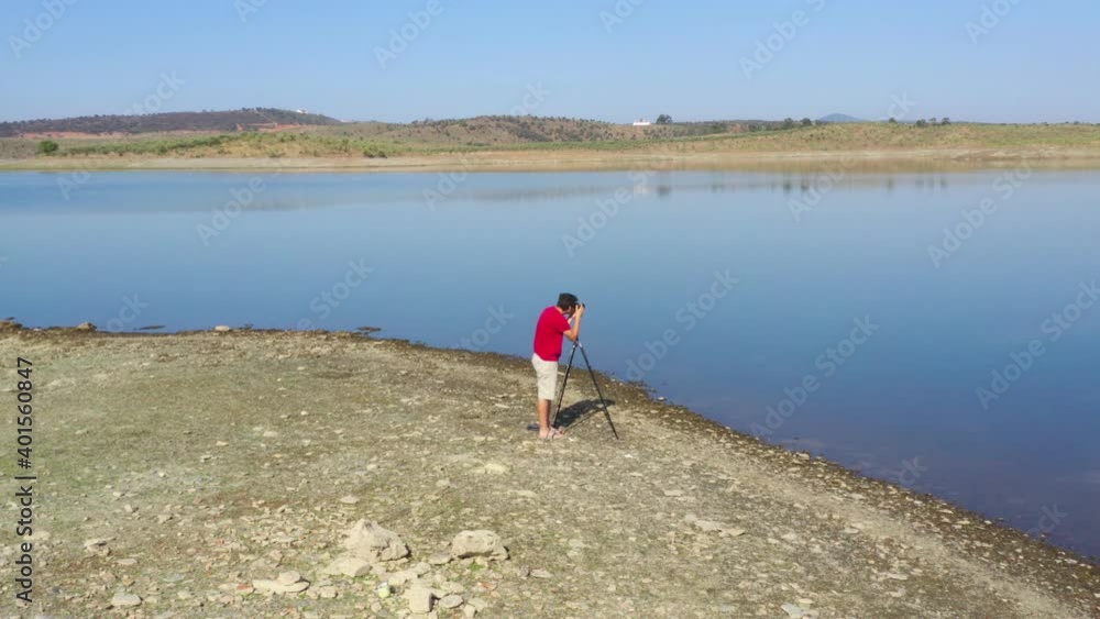 Drone shot of a caucasian man photographing a Landscape with a lake and reflection in Alentejo, Portugal Drone shot of a caucasian man photographing a Landscape with a lake and reflection in Alentejo, Portugal