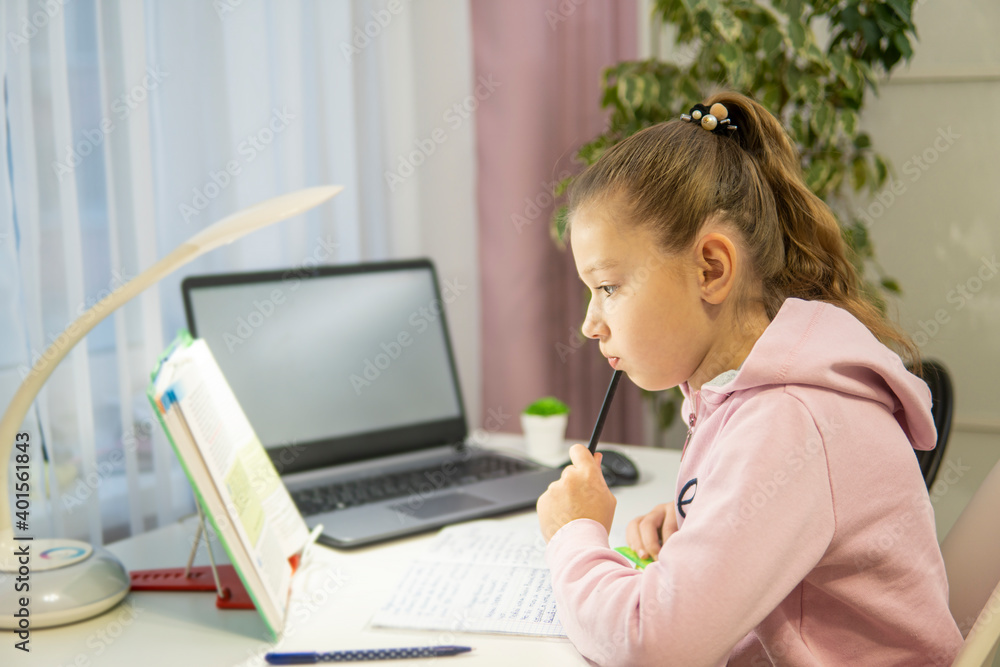 home-schooling. girl doing lessons in front of a laptop home-schooling. girl doing lessons in front of a laptop