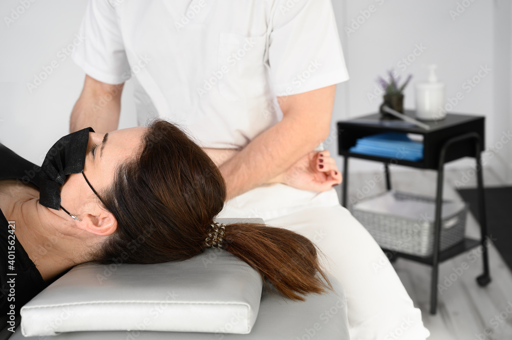 Male therapist giving massage to relief shoulder pain to a female patient in physiotheraphy clinic. High quality photo. Male therapist giving massage to relief shoulder pain to a female patient in physiotheraphy clinic. High quality photo.