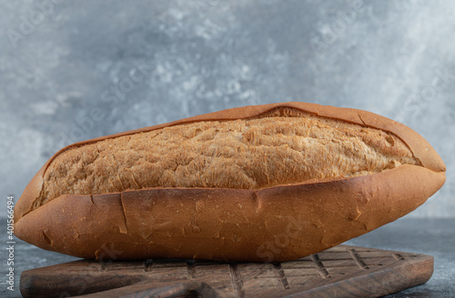 Photo of loaf of bread on wood cutting board photo