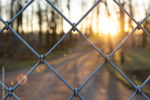 Chain-link fence at sunset. Steel link Close-up horizontally.