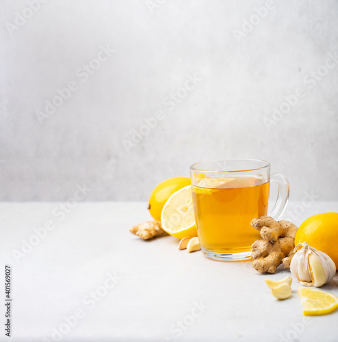 Hot herbal tea with ginger, garlic, lemon and honey vitamins C over grey background. Concept alternative medicine, natural homemade remedy for cold and flu. Support the immune system. Well-Being and