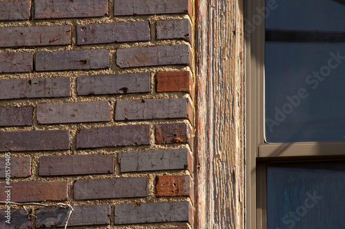 Juxtaposition of an Old Textured Window Frame and Colorful Brick and Mortar Wall