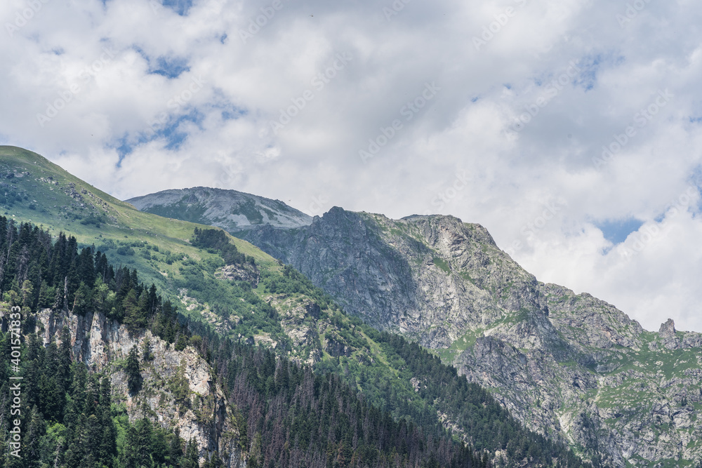 Amazing mountain landscape in summertime. Mighty mountains in cloudy weather.