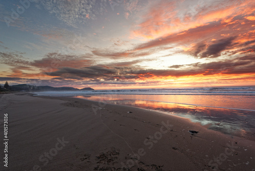 Golden sunrise across the ocean on a beach photo