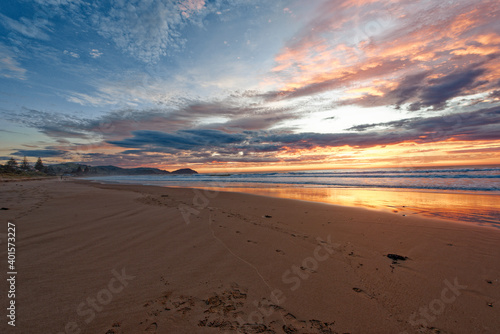 Golden sunrise across the ocean on a beach © CeeVision