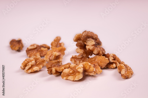 Several kernels of walnuts are on a white surface