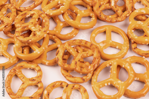 Scattered chaotically salted crackers close up on white background