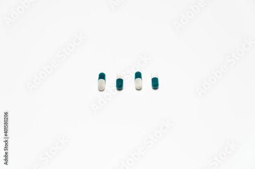 4 capsule pills lined up on a white background