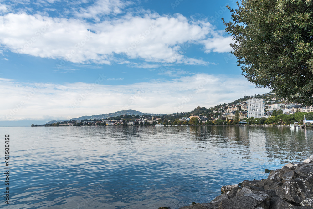 Obraz premium Lake shore surrounded by alpine mountains with buildings