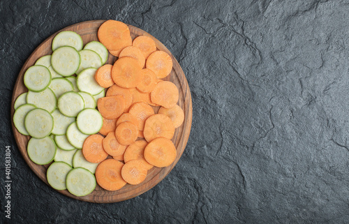 Zucchini and carrot slices on black background