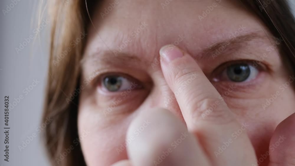 parts of a female face close up, woman plucking eyebrows with tweezers ...