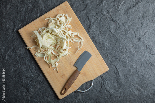 Photo of chopped cabbage and knife on the wooden cutting board