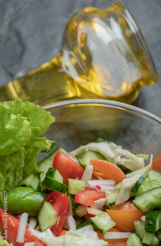 Close up vegetable salad and oil on black background