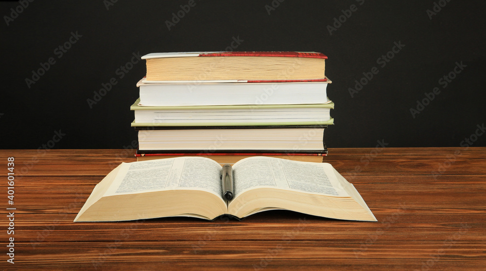 Open book on a stack of books on a table. Open book on a stack of books on a table.