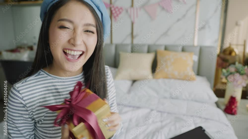The woman received a Christmas present at home. Excited woman with Christmas Gift.Asian woman count down and celebrate new year party via video call conference. The woman received a Christmas present at home. Excited woman with Christmas Gift.Asian woman count down and celebrate new year party via video call conference.