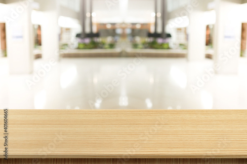 Empty wooden table in front of a blurred background. Brown wood in blurry view in office work - can be used to display or edit your products, simulate to showcase them.