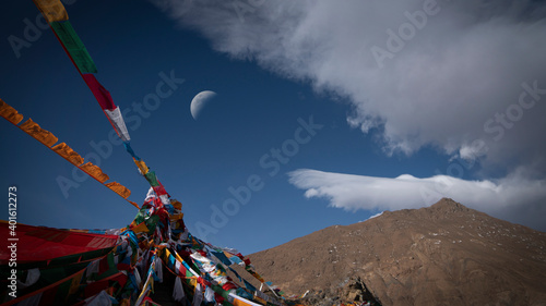 tibetan prayer flags in region,moon,blue sky and white clouds.