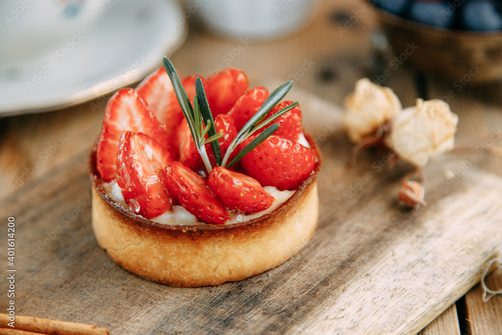 Sweet cakes with berries on a wooden table close-up. Cake made of yeast-free dough with strawberries and raspberries. Sweet cakes with berries on a wooden table close-up. Cake made of yeast-free dough with strawberries and raspberries.