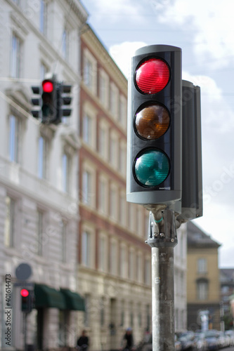 Traffic light on the street of the old European city. Red light, stop, don't go. Historical architecture of lively and picturesque city center. Prohibition or ban concept.