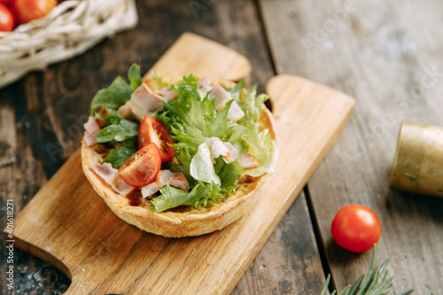 Hot appetizer with mushrooms, chicken and herbs. Tartlet made of yeast-free dough close-up.