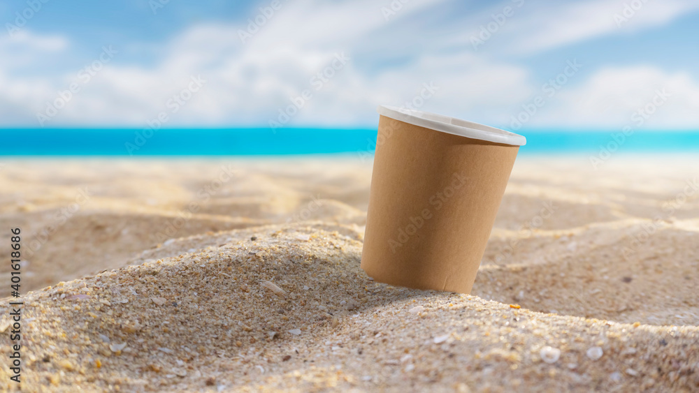 Paper coffee mugs Laying on the sandy beach in summer.