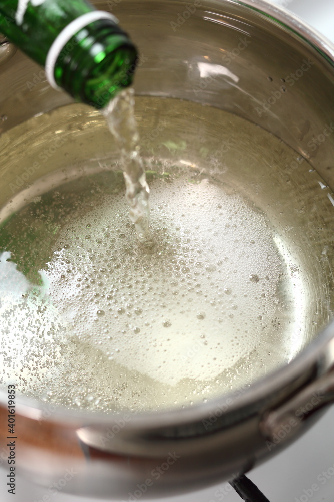 Pouring sparkling wine into saucepan Pouring sparkling wine into saucepan