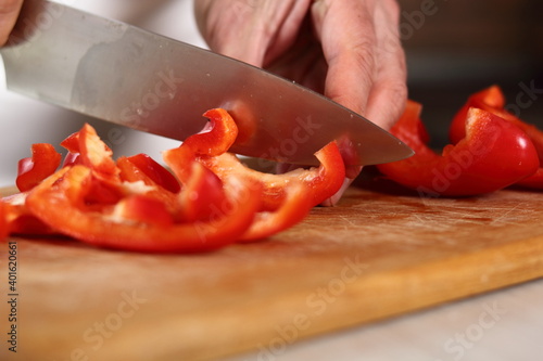 Chef slicing red bell pepper