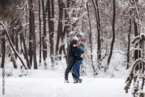 The guy hugs the girl and kisses in the snowy winter forest © Aleksandr