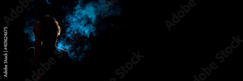 Colored silhouette of a smoking man on dark background. Banner panoramic. Copy space for text message.