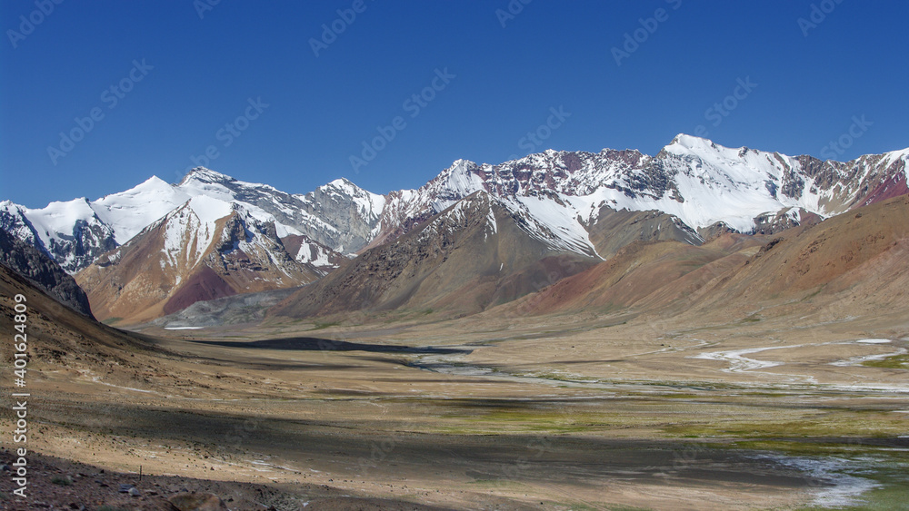 Colorful panorama of snow-capped mountains along high-altitude Pamir Highway between Ak Baital and Karakul, Murghab, Gorno-Badakshan, Tajikistan