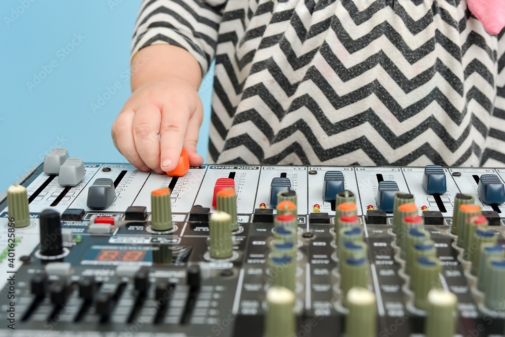 A little girl moves the faders on the mixer back and forth. A little girl moves the faders on the mixer back and forth.