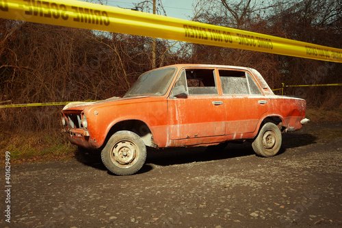 Fototapeta Naklejka Na Ścianę i Meble -  Older red car burned by criminals examined by police technician