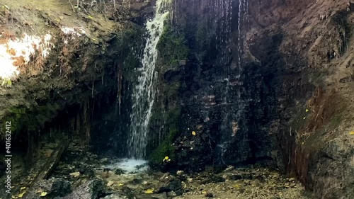 Slow-motion footage of a forest waterfall with clean, clear drinking water on a sunny summer day
