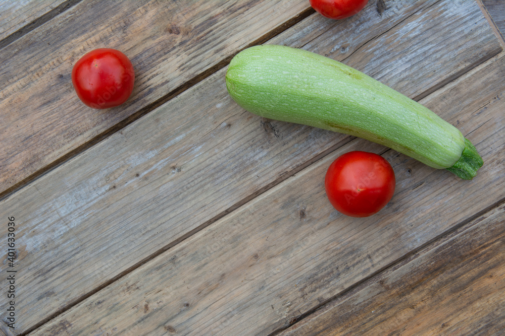 Tomatoes and zucchini on a wooden table background Tomatoes and zucchini on a wooden table background