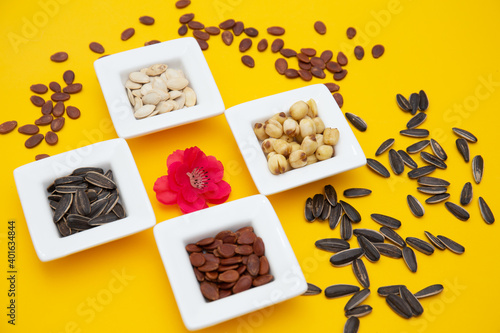 Tet Holiday, Lunar new year, chinese new year concept . Dried sunflower, lotus, watermelon and pumkin seeds top view isolated on yellow 