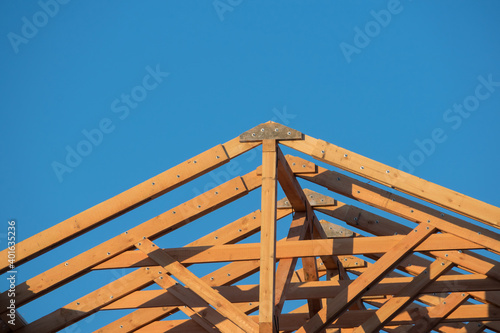 Canvas Print Close-up of the roof Gables on a stick built house under construction and blue sky