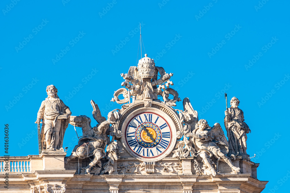 Clock surrounded by marble statues on the roof top of building in Vatican City