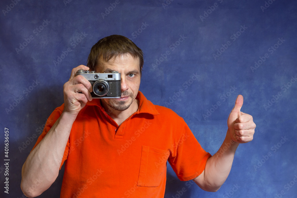 A 40-year-old European man holds a camera in his hands. A 40-year-old European man holds a camera in his hands.