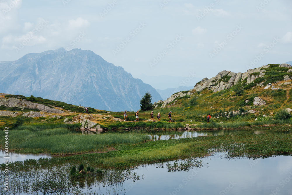 des randonneurs marchant vers un lac de montagne. Un lac de montagne dans les Alpes.