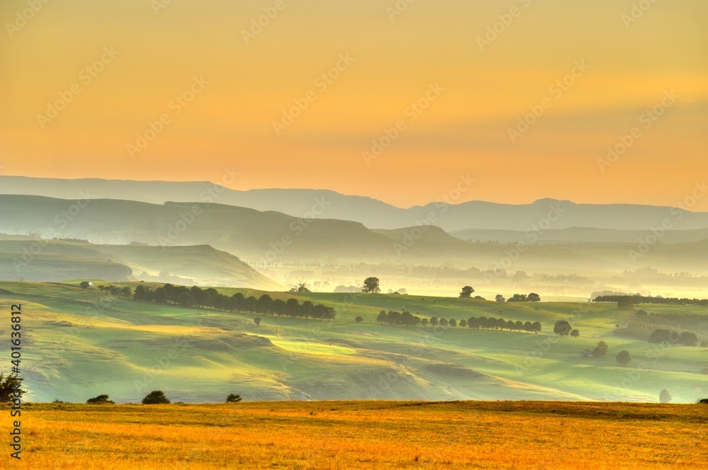 Fototapeta premium DRAKENSBERG FOOTHILLS IN THE DAWN. Summer sunrise over farmlands, district Underberg, Kwazulu Natal, South Africa