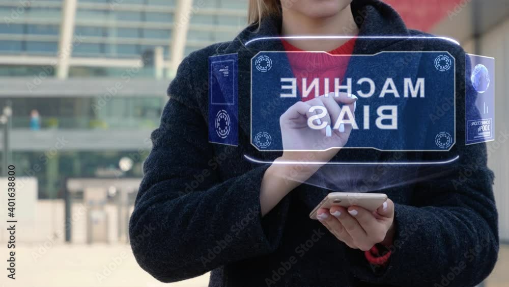 Unrecognizable woman interacts HUD hologram with text Machine Bias. Girl in the coat uses the technology of the future mobile screen on the background of the city