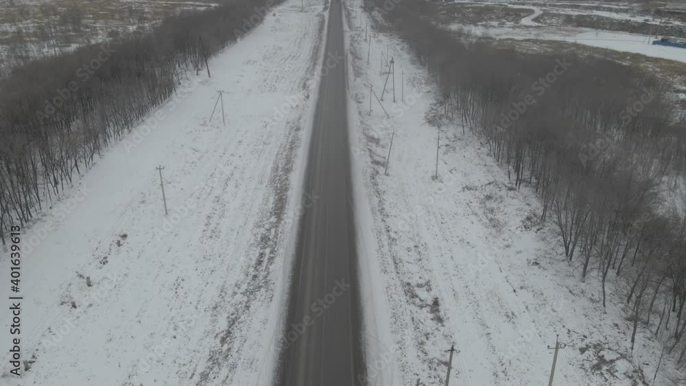 Aerial photography of the winter forest and the road. Tall pine trees covered with snow Aerial photography of the winter forest and the road. Tall pine trees covered with snow