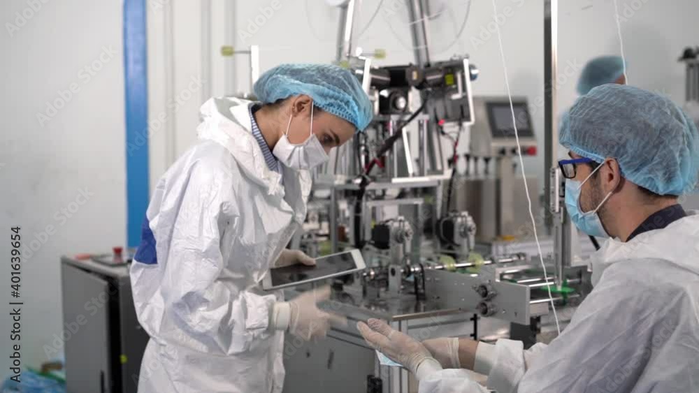 Employees in a mask factory Checking the quality of products on modern industrial machines. Employees in a mask factory Checking the quality of products on modern industrial machines.