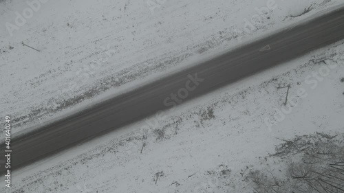  Aerial photography of the winter forest and the road. Tall pine trees covered with snow