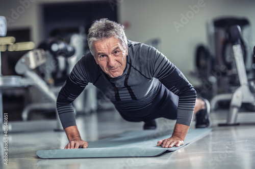 Age is just a number to a man with grey hair doing pushups in a gym