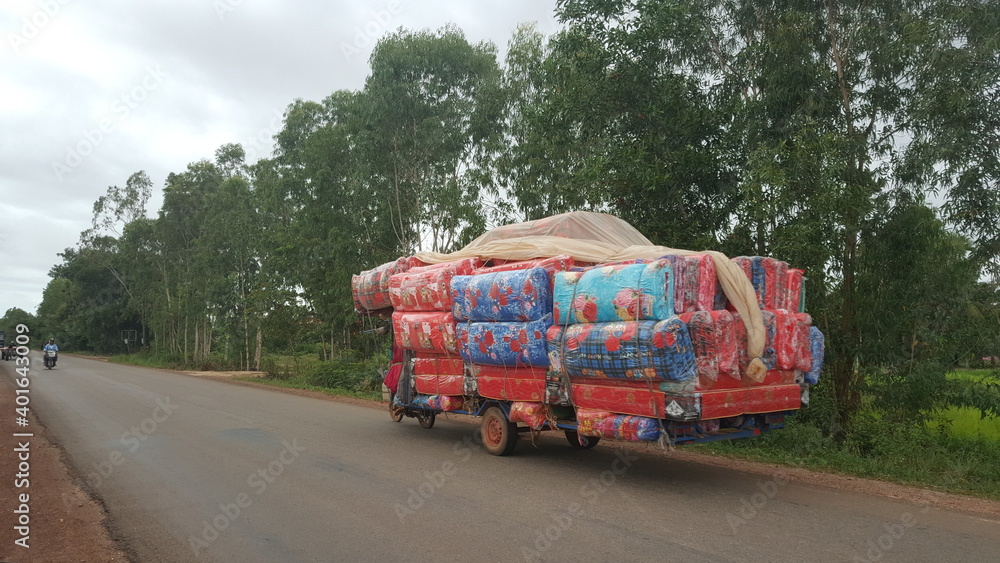 Often in Cambodia, you can see how the Kmers transport cargo on mopeds. Siem Reap province.