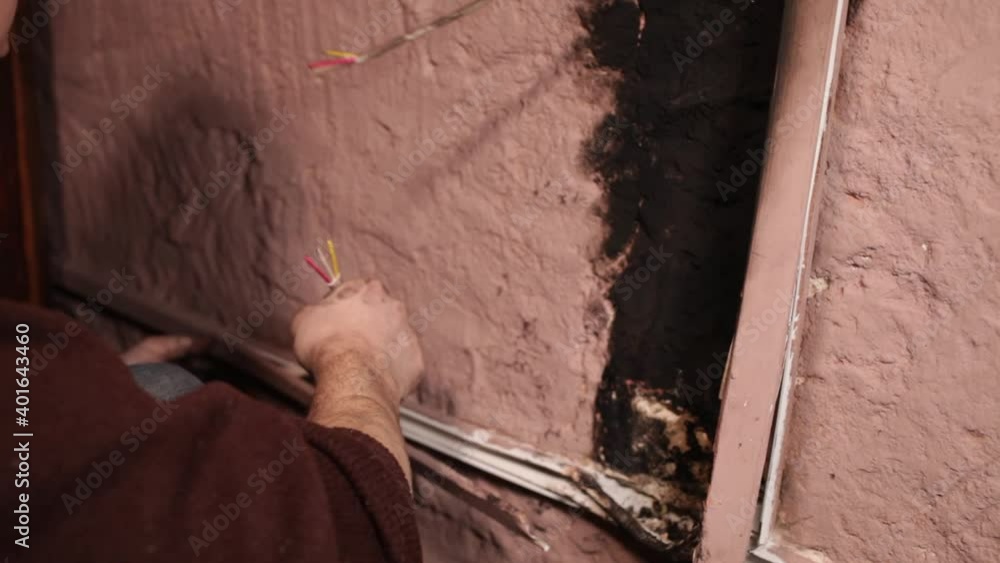The man eliminates the effects of the fire. Burnt socket, electricity
