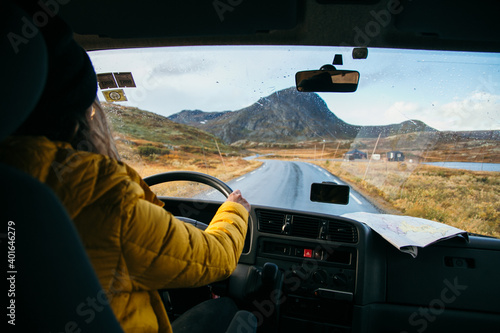 Young woman drive camping van on epic mountain road. Female adventurer travel in remote locations to camping destination. Vanlife lifestyle for urban travellers 